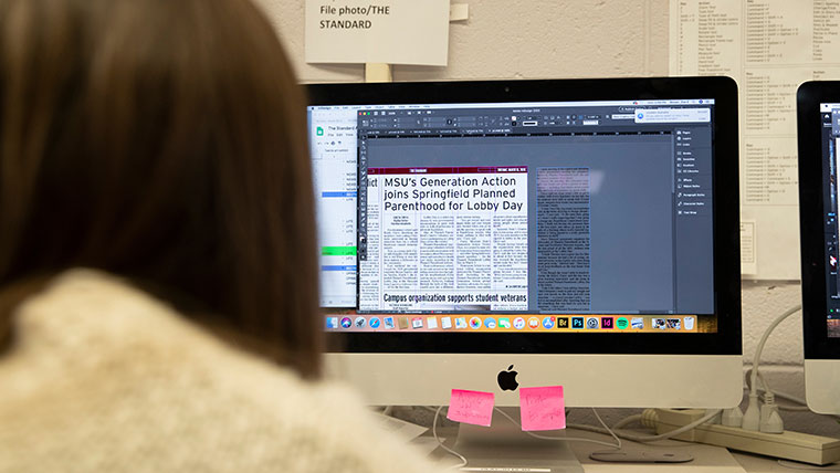 A student reporter edits a news page for The Standard, Missouri State's newspaper.