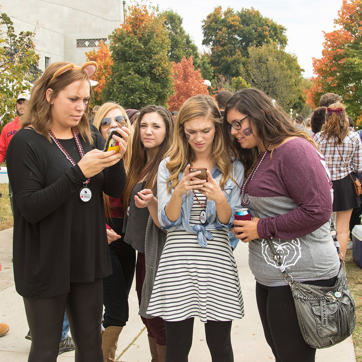 Five women scroll on their phones
