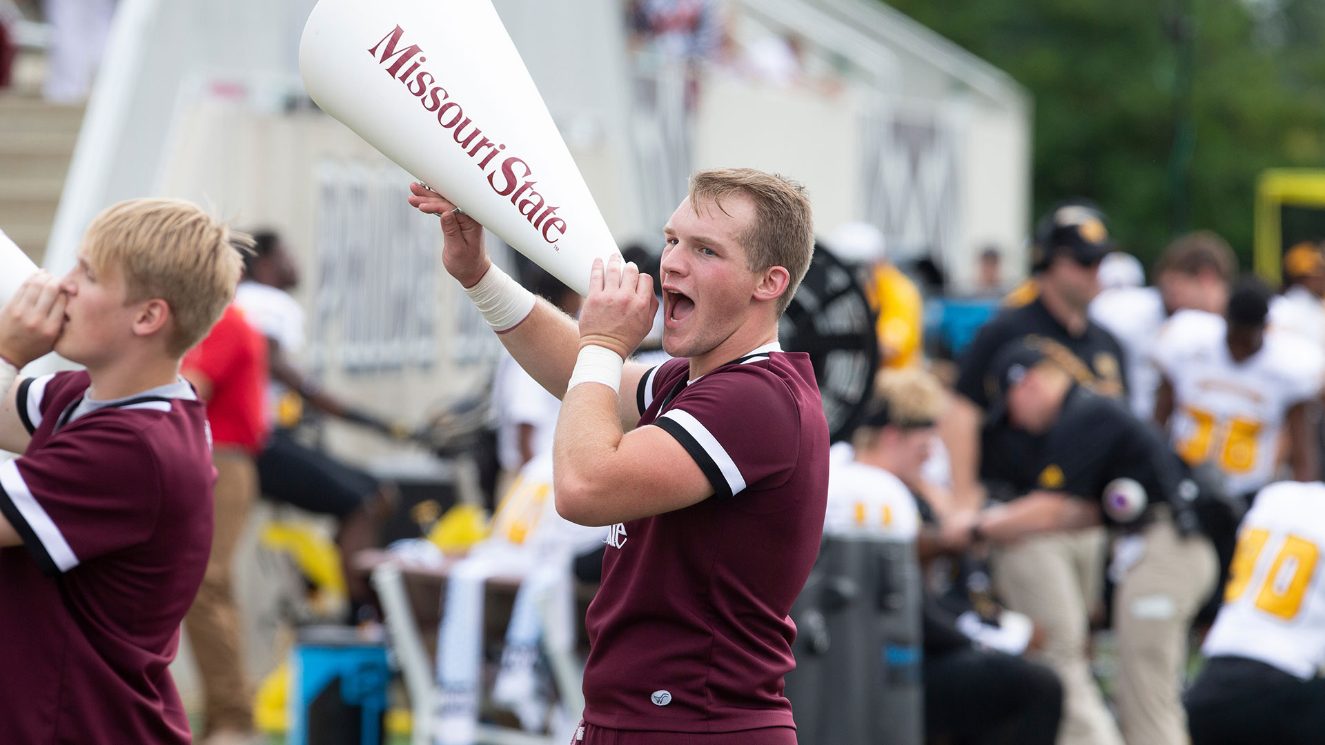 Two cheerleaders shout into megaphones.