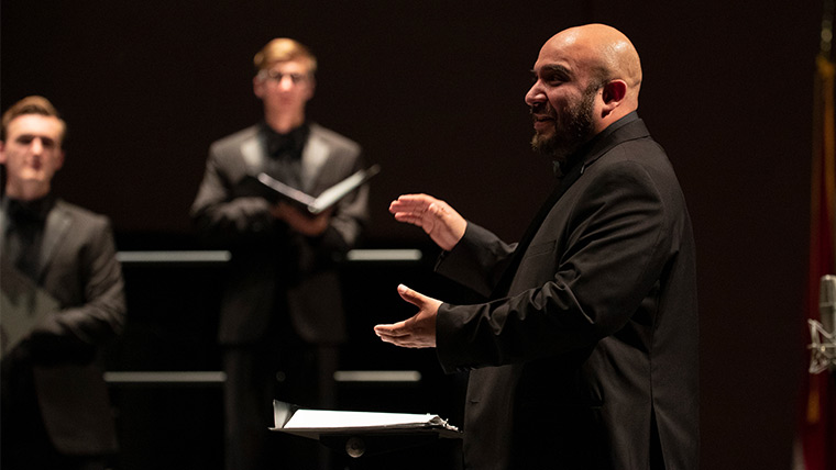 A graduate student conducts during a performance.