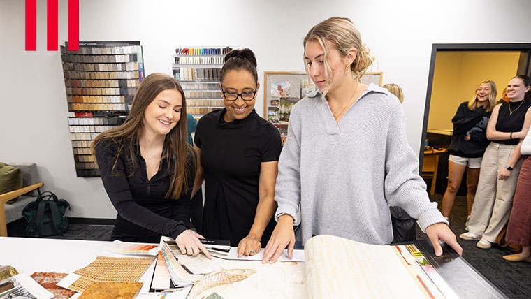 Students discussing the interior design program while looking at swatches.