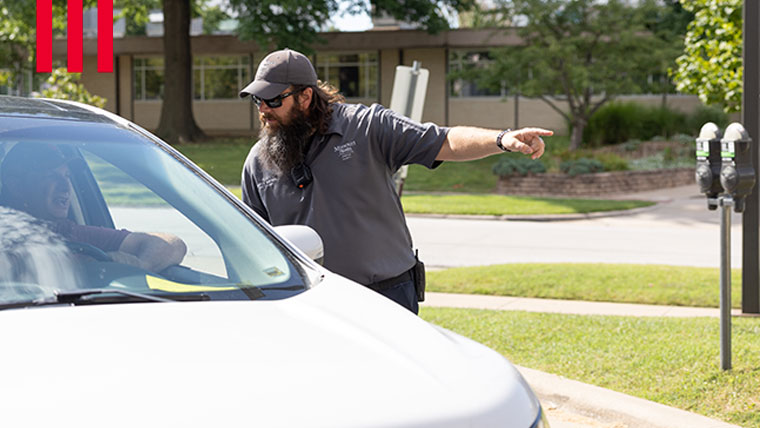 Safety officer directing a person in a car.