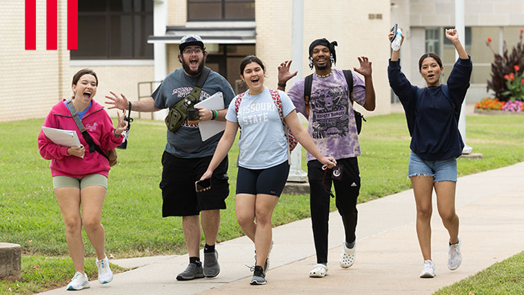Students walking on campus as a group.