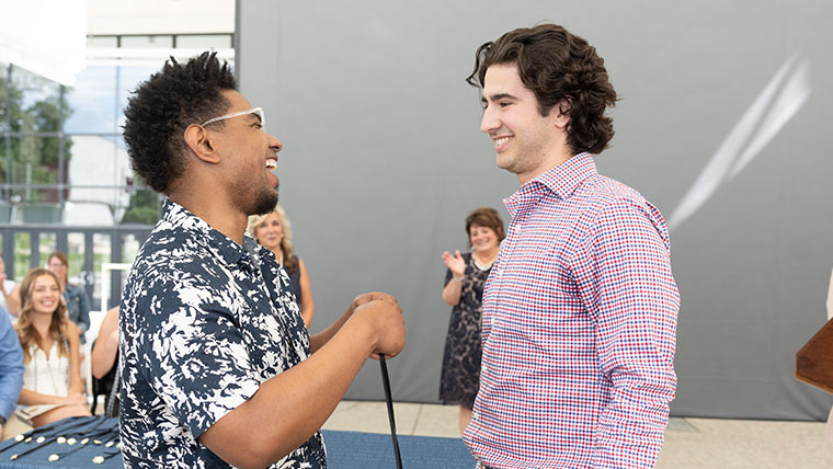 Student and professor sharing a laugh at the pinning ceremony.