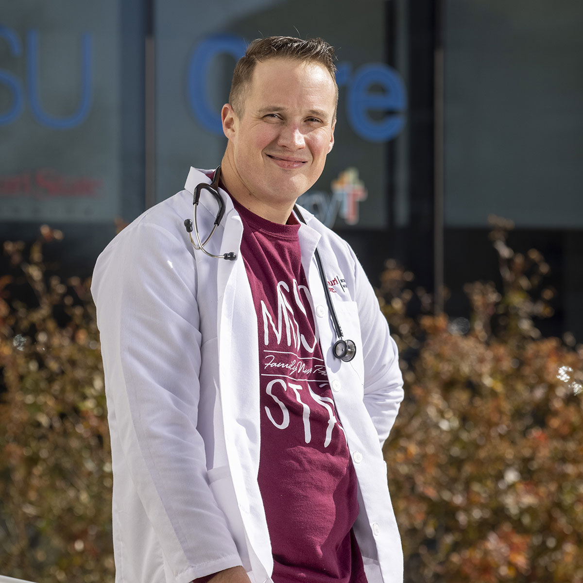 A DNP student smiling outside a care clinic.