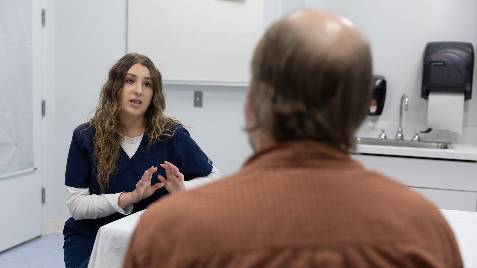 A nursing graduate student informs her patient on a medical treatment.