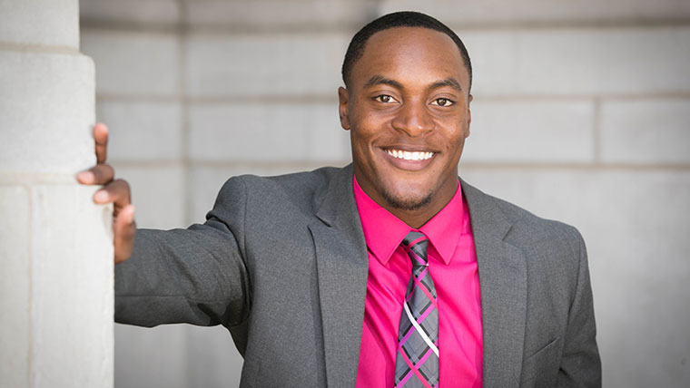 Accounting major Alex Jefferson poses next to a building.