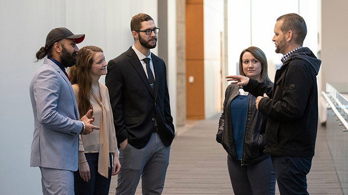 Students and professors in a hallway discussion