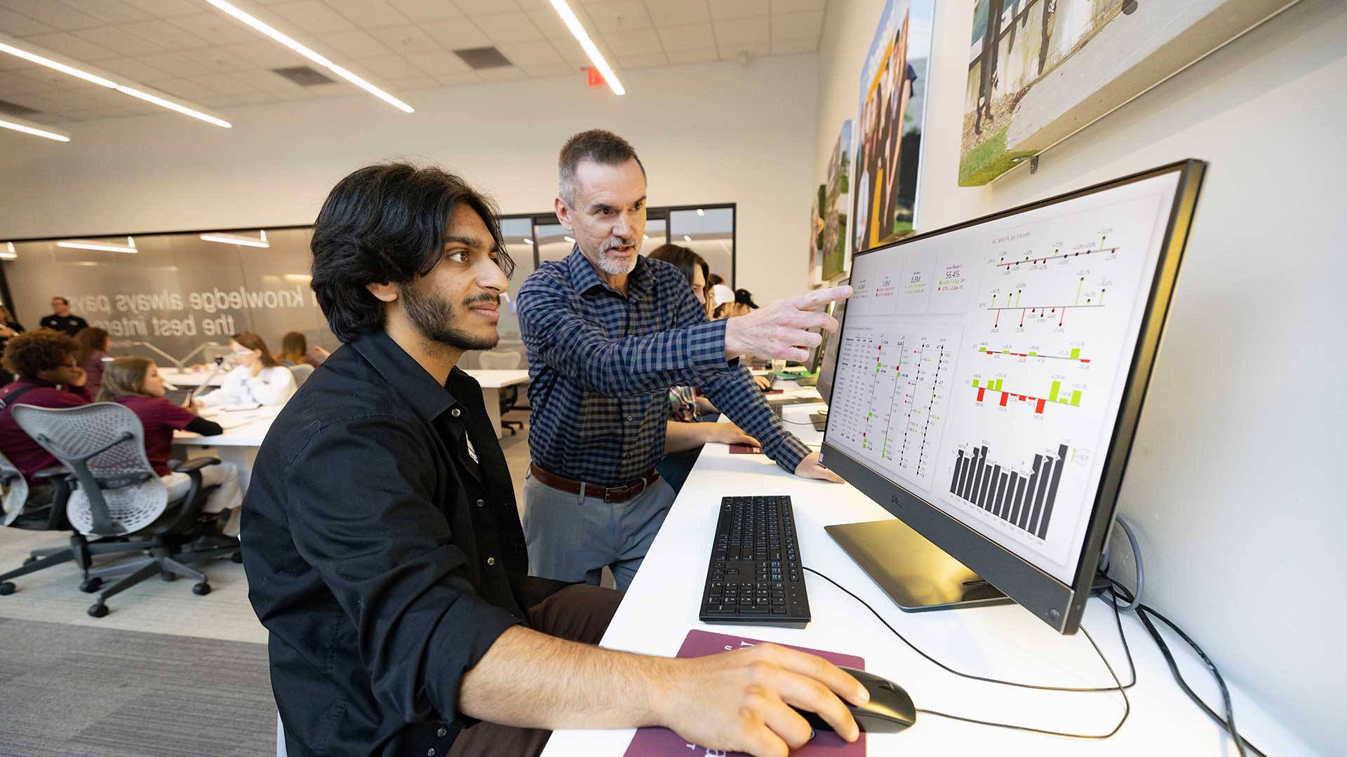 A professor assisting a student within the classroom.