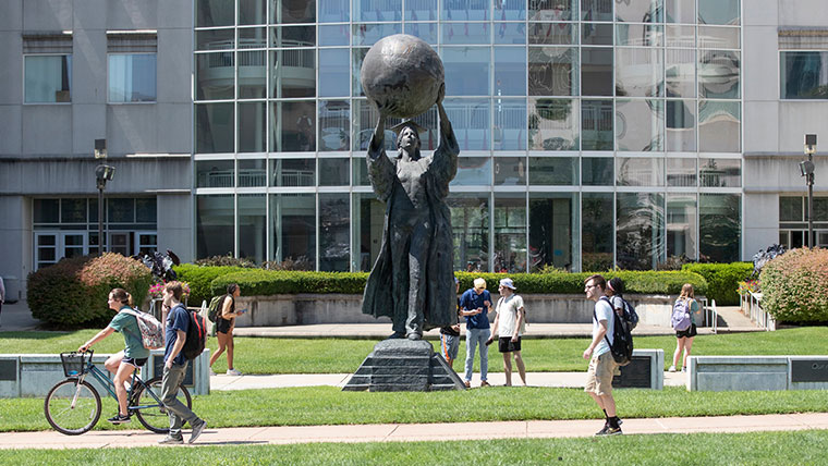 Students walking in front of the Citizen Scholar statue on the Missouri State campus.
