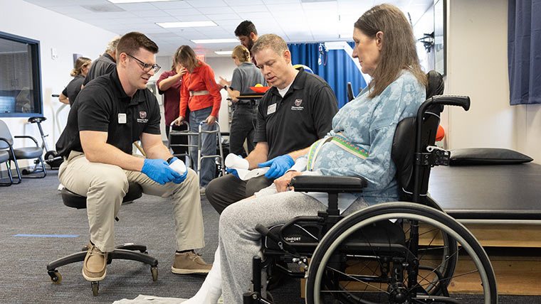 A physical therapy student and professor tending to a client at the Physical Therapy Clinic.