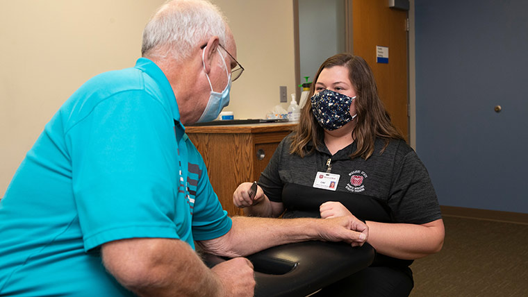Trainer working on patient's arm.