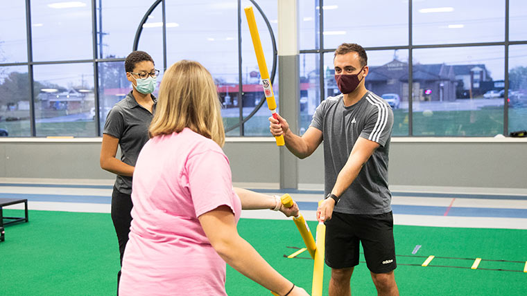 Athletic training students doing demonstrations in clinical setting.