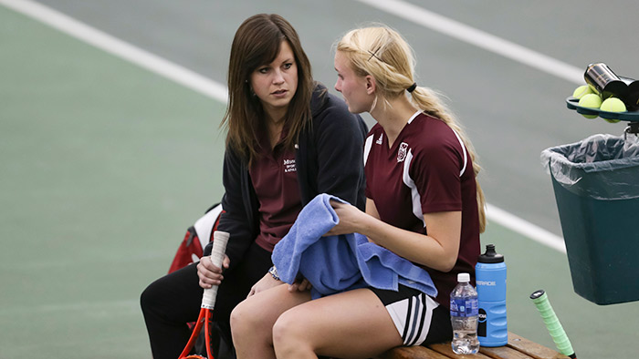 Trainer talking to tennis player.