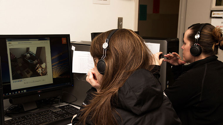 A counseling student reviews a recorded session to observe and improve her therapy techniques.