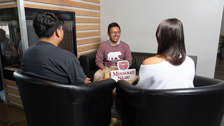 An admissions counselor talking to two students.