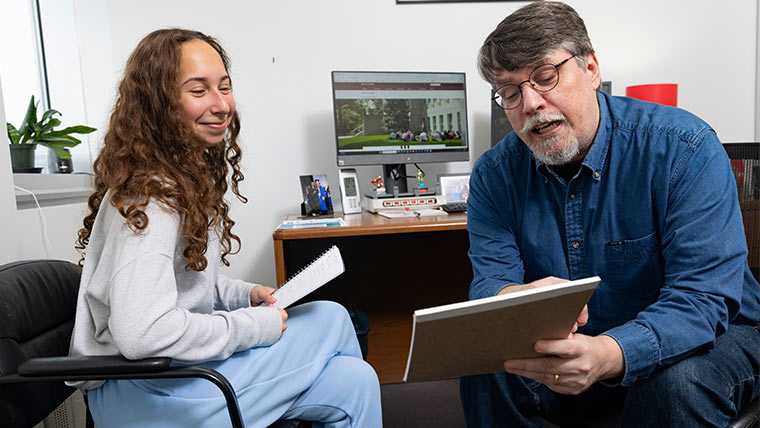 A student talks with her advisor about a degree audit.