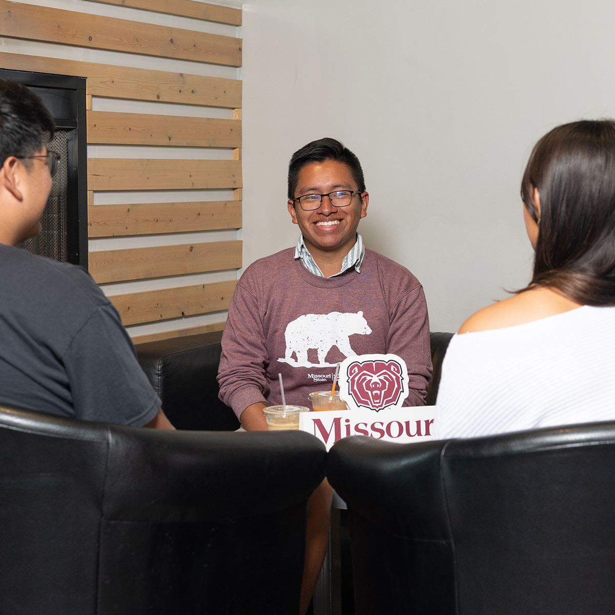 An admissions counselor talking to two students in his office.