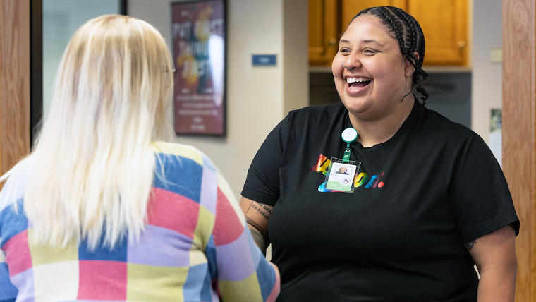 A student of the undergraduate social work program greets a community social work professional