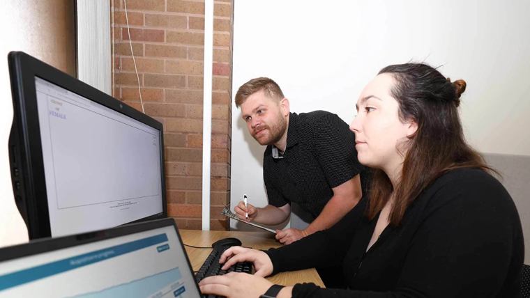 A psychology professor instructs a behavior analysis and therapy student on software