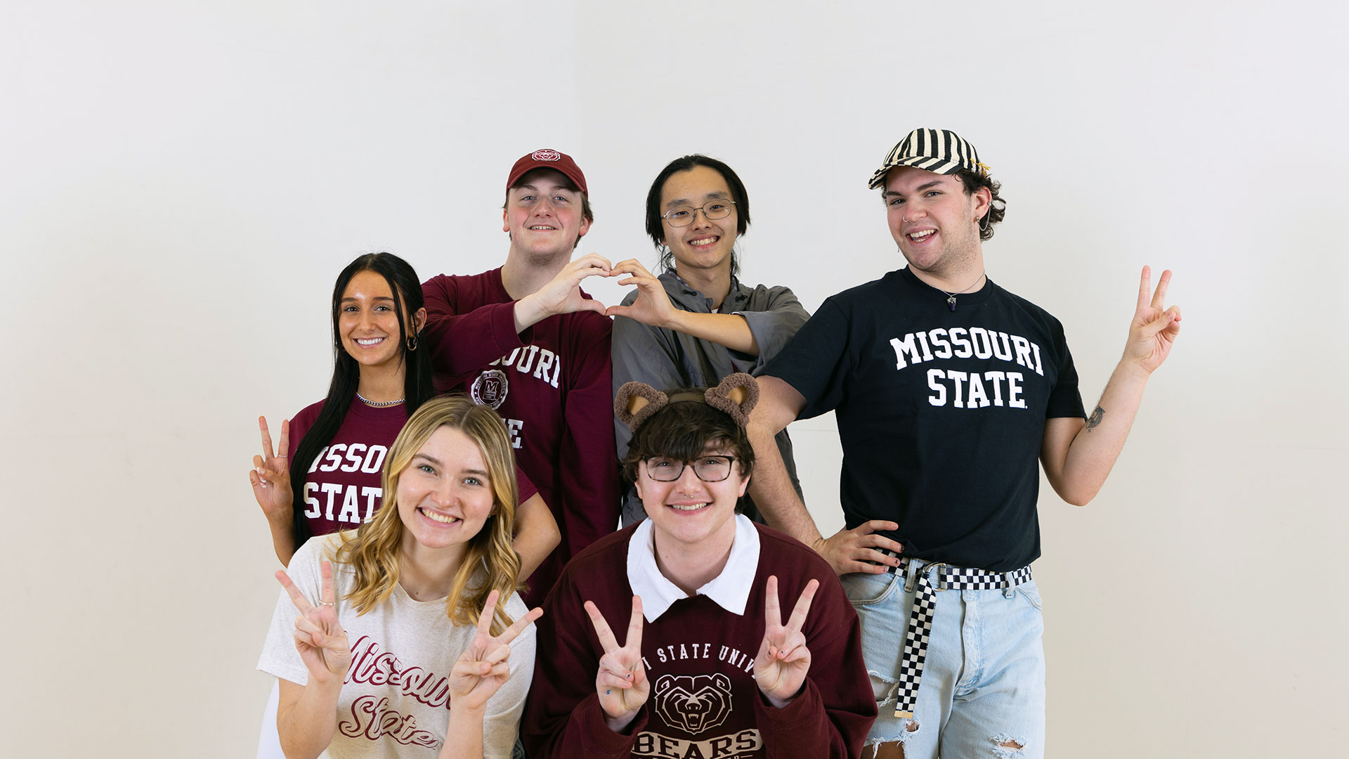 Smiling Missouri State students giving the peace sign. 