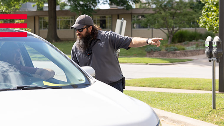 Safety officer directing a person in a car.