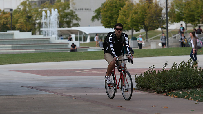 Student biking on a bike path