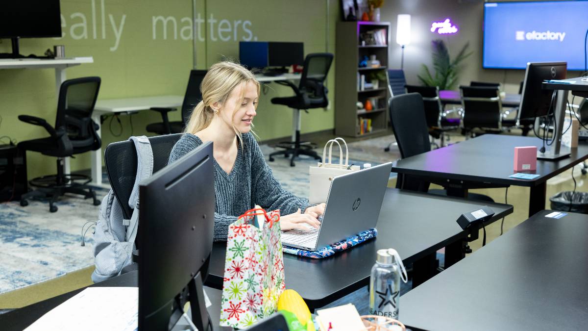 Young woman sits at laptop