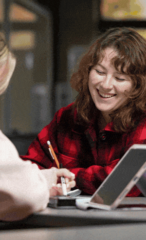Student sits with child in a gymnasium