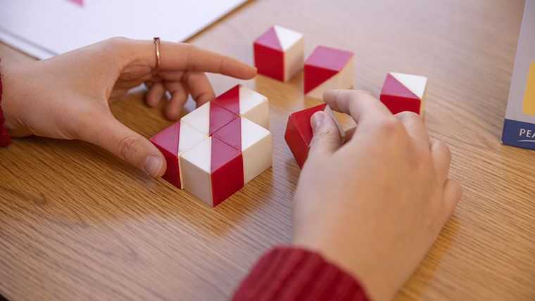 A person arranges striped cubes during an IQ test at the Learning Diagnostic Clinic.