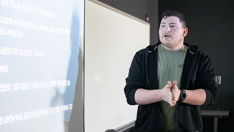 A student gives a presentation about meteor impacts.