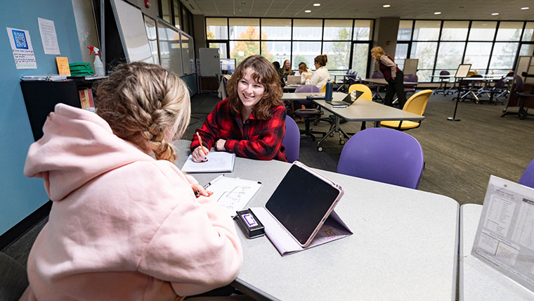 A tutor helps a student study her notes at the Bear CLAW.