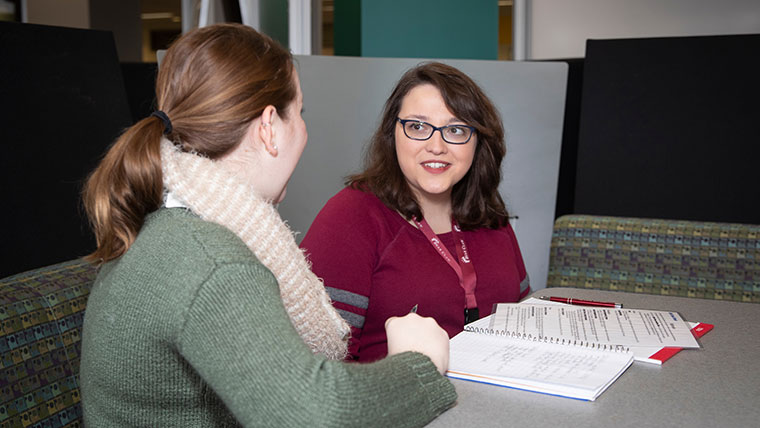 Students Maria Meluso and Victoria Dickson discuss an assignment in the Writing Center at the Bear CLAW.