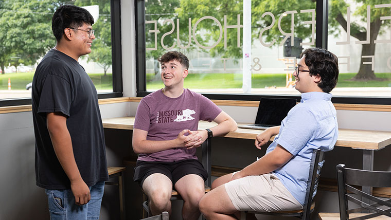 Three students chat about the admissions process.