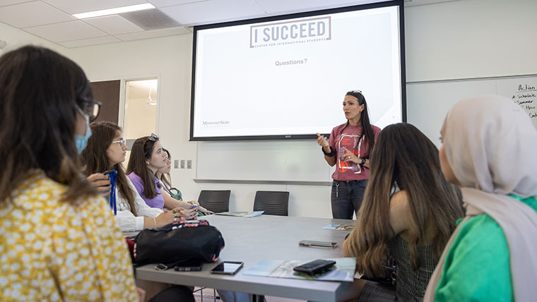International students listen to a presenter speaking about I Succeed (the Center for International Students) during orientation.