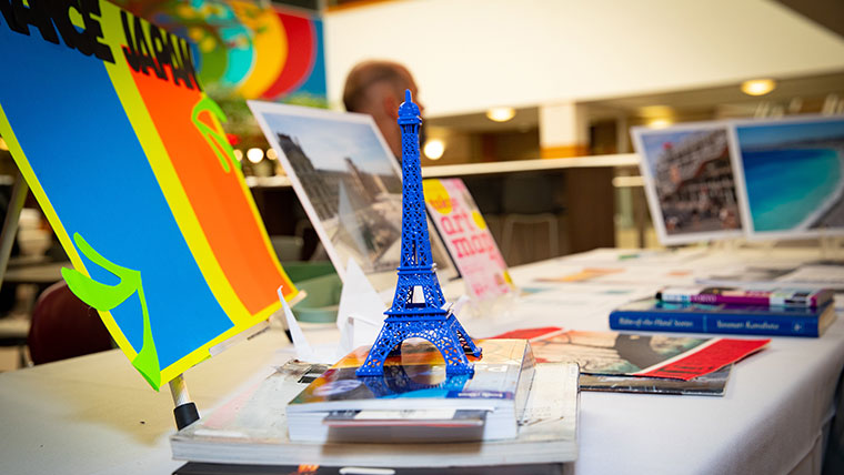 Travel mementos and postcards are displayed on a table at a Study Away Fair.
