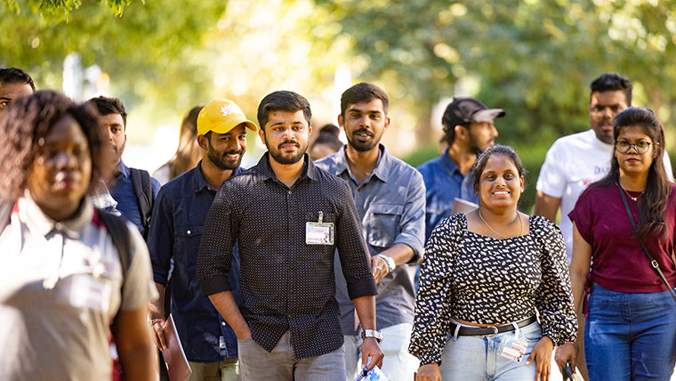 A group of international students take a stroll while touring campus.