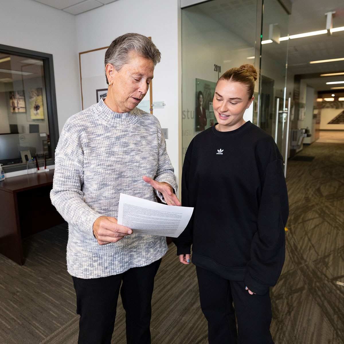 Beth Perine, an athletics academic advisor, explains a form to her advisee.