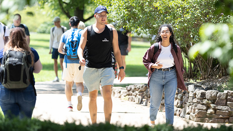 Two students walking to class on a warm day.