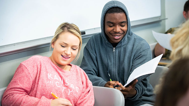 Two students smiling in class.