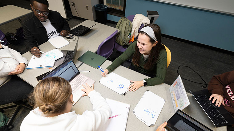A study group meets at the Bear CLAW. Students use white boards, laptops and notebooks to take notes.