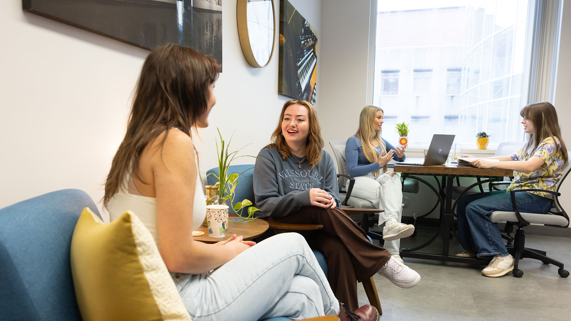 Two pairs of RCASH students have one-on-one chats in a general seating area.
