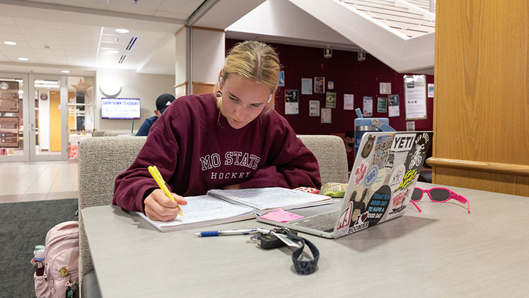 A student highlighting her notes in the Plaster Student Union.