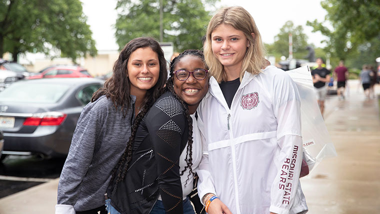 Three smiling Missouri State students on the MSU campus. 