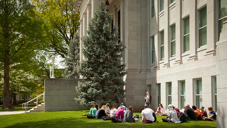 Class sitting on grass outside of Siceluff Hall