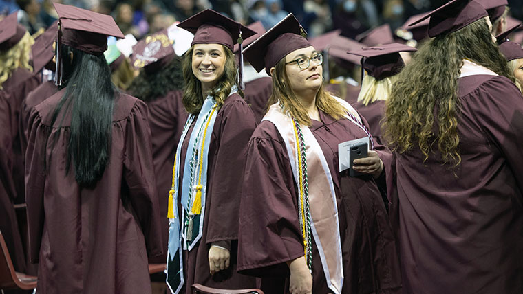 Missouri State students at commencement in cap and gown.