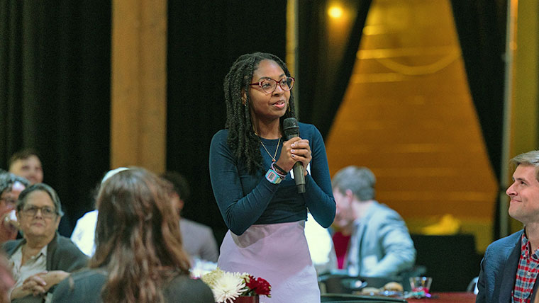 Missouri State student standing with a microphone at the reception. 