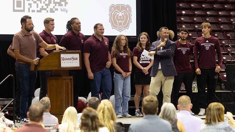 Missouri State students on the stage with host.