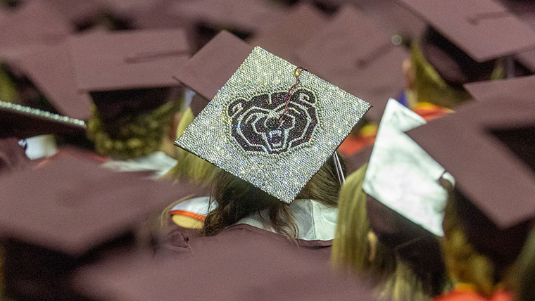 A mortar board with a Bear head made of sequins.