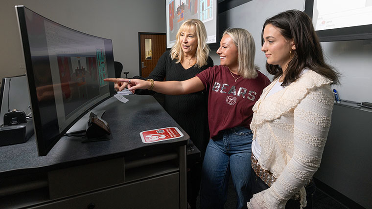 Missouri State faculty looking at computer monitor with two students. 